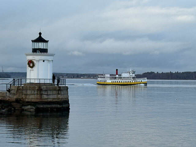 A Casco Bay Ferry passing Portland Breakwater Light in Portland, Maine
